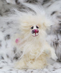Snowdrop is a particularly small and adorable snowbear, a one of a kind artist bear in fluffy, snowy silk and mohair by Barbara-Ann Bears. Snowdrop stands just 5 inches (12 cm) tall and is 4 inches (10 cm) sitting, this doesn't include the long plumes of white mohair that swirl about her head, these add a further 3 inches (7.5cm).