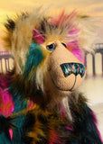 Theodore Toot has large, beautiful, hand painted glass eyes with hand coloured eyelids, he has a carefully embroidered nose that incorporates all of his colours and a sweet, thoughtful smile. Theodore Toot is mostly made from a very long, shaggy and dense faux fur which is black with bands of magenta, mustard and cyan and Theodore's face and the fronts of his ears are made from a very long and soft golden blond mohair. 
