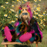 Theodore Toot is a very shaggy wild and colourful, one of a kind, artist teddy bear by Barbara-Ann Bears, he stands 19 inches/48 cm tall and is 15 inches/38 cm sitting. He is  made from a black magenta, mustard and teal dense faux fur and very long soft golden blond mohair, with hand painted eyes and many coloured nose