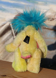 Timmy is made from several different fabrics, he's mostly a short, straight and dense mohair that Barbara has hand dyed a beautiful sunny yellow. His tummy and the underside of his tail are a dense, soft pink faux fur with black rosettes (like a pink panther), his face is a long wispy white mohair, the top of his head and the backs of his ears are a long fluffy aqua faux fur with plumes of even longer white faux fur and the fronts of his ears are a fluffy mohair that Barbara has hand dyed a warm orange
