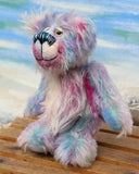 Tim Pimpling is a happy, little one of a kind, mohair artist bear by Barbara-Ann Bears. Tim stands 6.5 inches( 16 cm) tall and is 5 inches ( 13 cm) sitting. He is mostly made from a medium length, slightly distressed and fluffy mohair that Barbara has hand dyed in sky blue with some splashes of magenta, pink and lilac